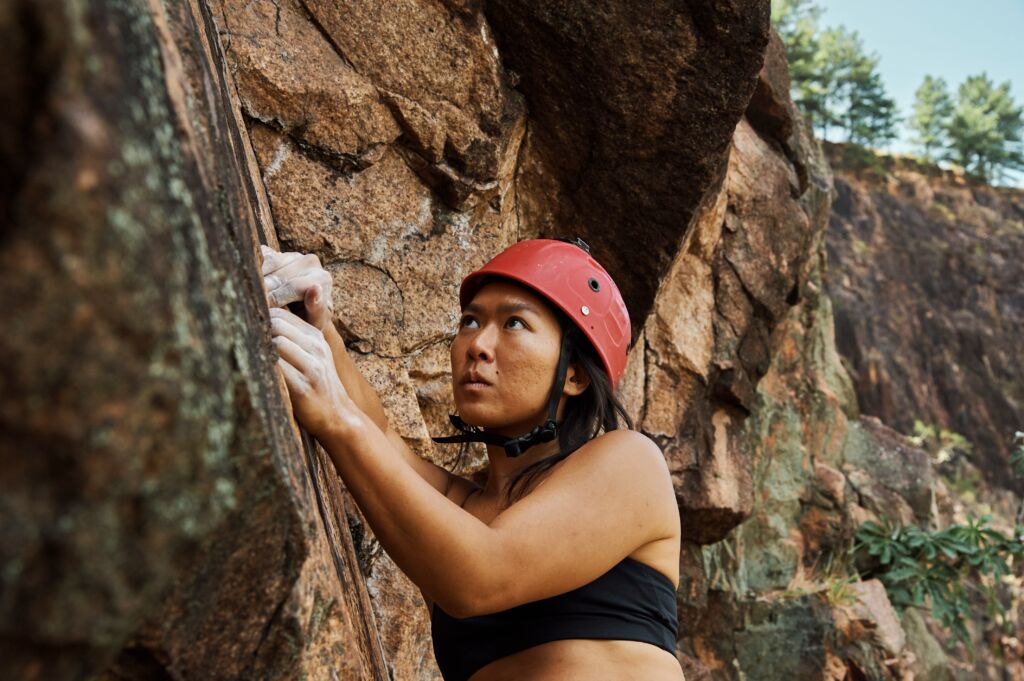 Femme asiatique escaladant une falaise