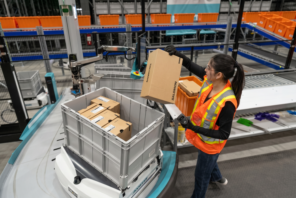 Préparatrice logistique préparant des commandes dans un entrepôt automatisé de l'industrie du sport et de l'outdoor.
